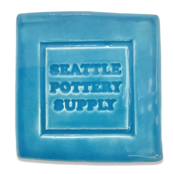 A glaze tile in Happycozygoods glaze SP77 Turquoise, stamped with Happycozygoods